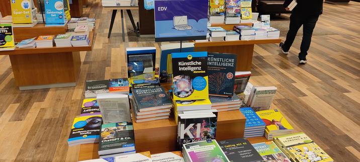 Ein Büchertisch in einem Thalia. Auf dem Schild steht "EDV", die Bücher handeln alle mehr oder weniger von KI