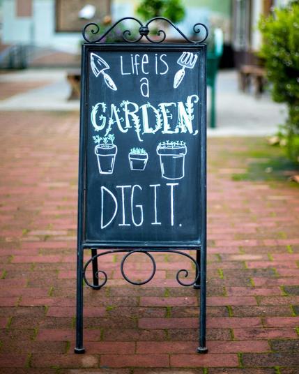 picture of a sign with the text “Life is a Garden, Dig It.”