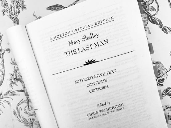 Pictured is the title page of Mary Shelley's postapocalyptic The Last Man (A Norton Critical Edition) against a backdrop of patterned wallpaper. The photo is black and white.