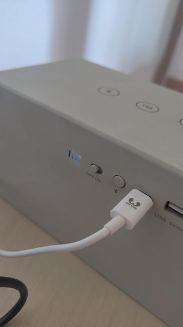 Bluetooth speaker with charger plugged in. The charging is in progress.