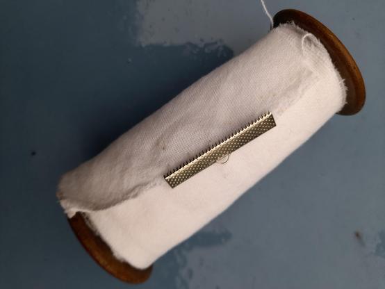 Example of a scroll book made with white tissue. A metal clip will hold the end to make it easier to roll up the book. You can either store it rolled up or hang it open on the wall.