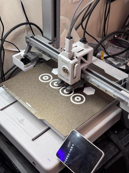 A 3D printer making a group of disc shaped puppet eyes
