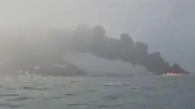 Massive plume of smoke rising over a ship