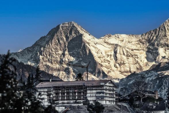 Schulhaus im Umbau mit Gerüst und Kran vor der Eigernordwand