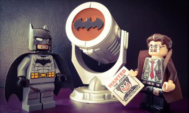 Batman and Commissioner Gordon, standing either side of the Bat Signal (in LEGO)