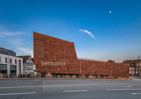 Seitenansicht eines modernen, kubistischen Gebäudes mit einer Fassade aus rostigen Corten Stahlplatten