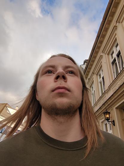 Man walking I the streets of bergen, buildings adorn the background.
