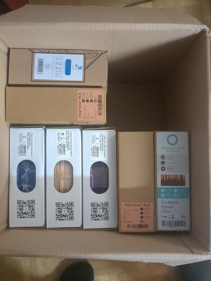 A box full of 3D printing filament. The box is full of PLA and PCTG spools.
