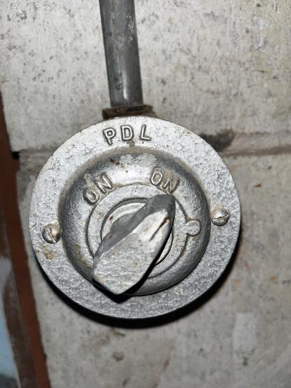 A photo of an old metal cast light switch, in an old basement. Weirdly, *both* switch settings are labelled “ON”.