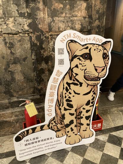 A fairly realistic looking illustration of a Formosan Clouded Leopard, printed on a hard paper with a couple of QR codes, which allow visitors to download National Taiwan Museum Smart App.