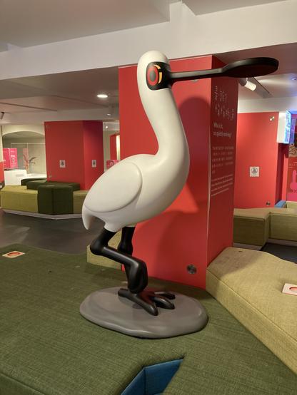 A large and tall model of a Black-faced Spoonbill. The bird looks slightly cartoonish, and mascot-like.