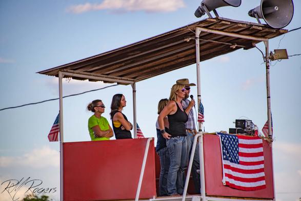 A group of people standing in the elevated announcer booth at a small town rodeo in southern Utah.