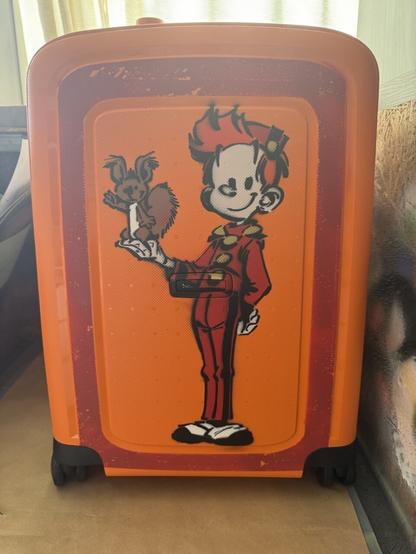Picture of orange Samsonite luggage with stencil graffiti of cartoon characters Spirou and Spip.