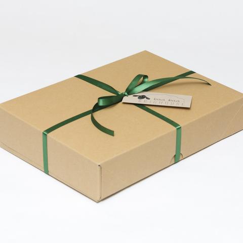 Picture shows a closed A4 box tied with green ribbon.