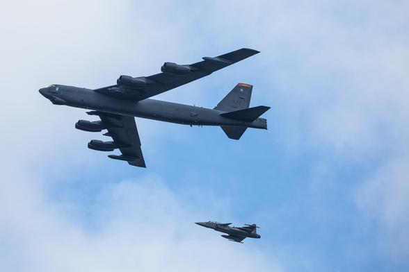 A B-52 Stratofortress flying over central Stockholm, escorted by a Swedish Jas39 Gripen fighter jet.