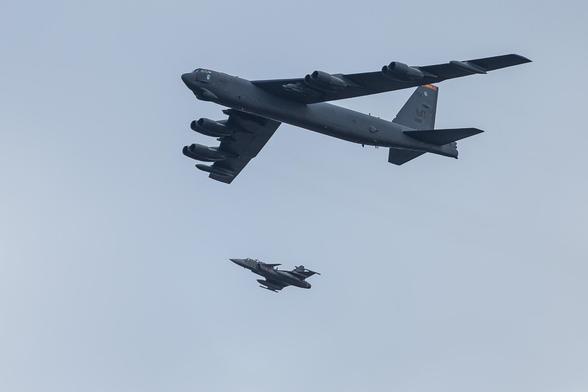 A B-52 Stratofortress flying over central Stockholm, escorted by a Swedish Jas39 Gripen fighter jet.