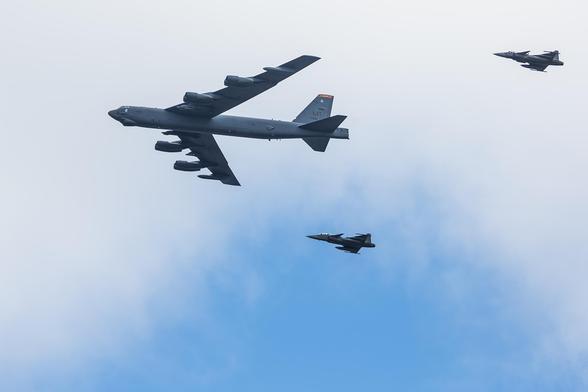 A B-52 Stratofortress flying over central Stockholm, escorted by two Swedish Jas39 Gripen fighter jets.