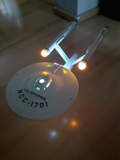 Die Enterprise schräg von vorne oben im leicht dunklen mit ihrer Beleuchtung fotografiert.