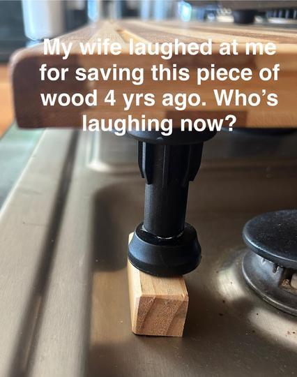 A small block of wood under the leg of a small table with the caption “My wife laughed at me for saving this piece of wood 4 years ago.  Who’s laughing now?
