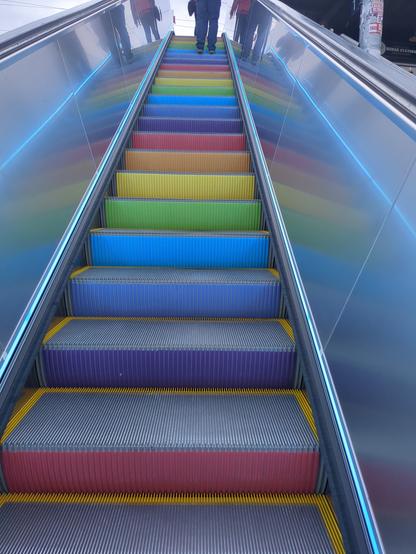 Rolltreppe, farbige Stufen: Gelb, Orange, Lila, Blau, Rot