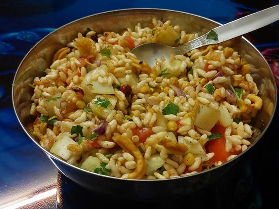Dinner tonight: a big steel bowl, with a steel spoon, of jhalmuṛi (spicy puffed rice). There's muṛi (puffed rice), chopped tomato + red onion + cucumber + coriander greens + green cayenne chili pepper + boiled potato, lime juice + pickled lime, bhaja môshla and salt, soaked Bengal gram, and Bombay mix.