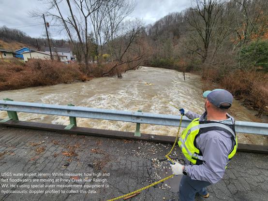 photo - USGS water expert Jeremy White measures how high and fast floodwaters are moving at Piney Creek near Raleigh, WV. He's using special water measurement equipment (a hydroacoustic doppler profiler) to collect this data.