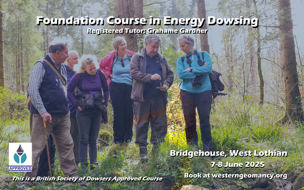 A group of people in a woodland watch somebody dowsing with a pendulum over a chart.