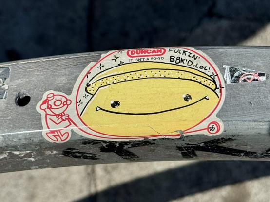 An old Duncan yo-yo sticker that says “if it isn’t a Duncan, it isn’t a yo-yo”. It shows a drawing of a man with a yo-yo. In the big negative space I’m the center of the yo-yo, a graffiti artist named Matsu has drawn one of his mushroom characters and added text that says “fucking b8ked. lol”. I think it’s worth noting this sticker was pasted onto a bike rack in front of a weed dispensary.