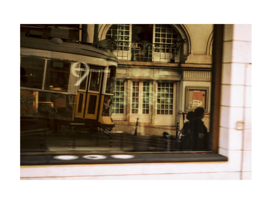 reflexions in a big shop window showing one of lisoba eletrico trams and buildings