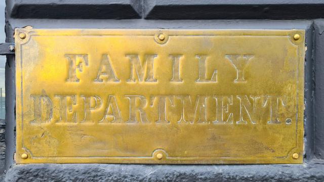 An old brass sign with the words Family Department embossed on it.