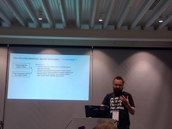 Speaker from SAP giving a talk on contributor journey optimisation standing in front of the slide