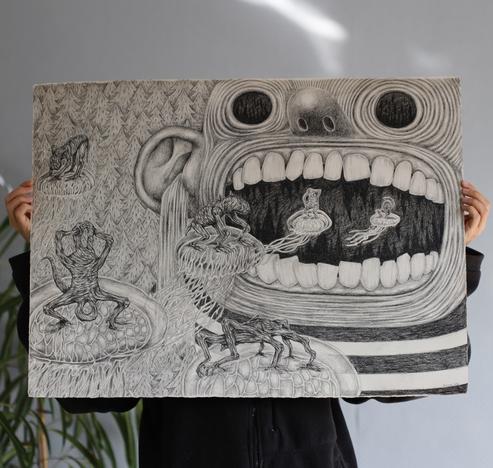 Photo d'un dessin très grand format présenté par une personne dont on ne voit que les mains et le bas du buste, le reste est caché par le dessin.
