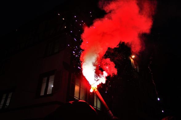 Un fumigène rouge allumé dans la nuit
