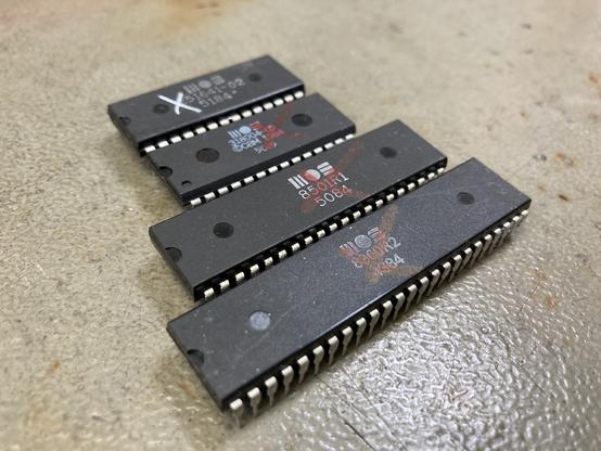 4 ICs on my workbench photographed at an angle. The chips are (from top to bottom) a C16 PLA, a C16 KERNAL ROM, an 8501R1 processor and an 8360R2 TED chip from a Commodore 16.