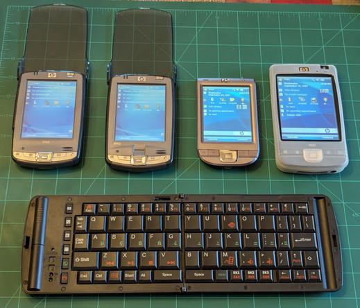 4 of my iPaqs lined up with the screens turned on.  Below them sits the Freedom Pro keyboard with it keys of all different sizes.  The keys are also branded with all kinds of different colored graphics.