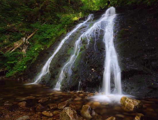 Das  Bild zeigt einen Wasserfall mit drei Wassersträngen