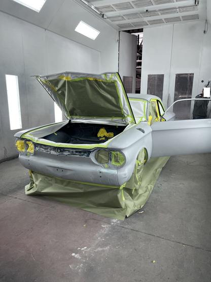 Front view of 1964 Corvair in paint booth, prepped for paint.