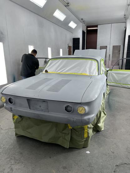 Rear view of 1964 Corvair in paint booth, prepped for paint.
