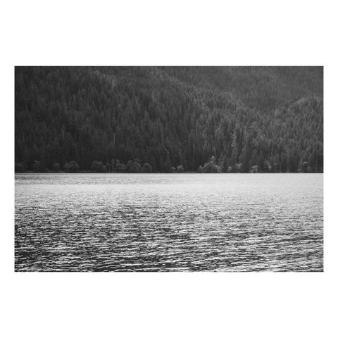 a lightly rippled lake ends at as a mountain rises on the far shore