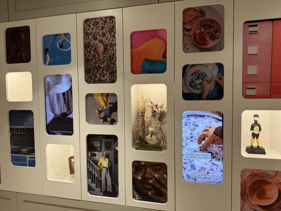 A collage of images displayed on a wall unit featuring various activities and subjects, including a portrait of an elderly woman, a person working on a craft, food arrangements, and decorative elements. Some images are framed with different colored backgrounds, while one screen shows