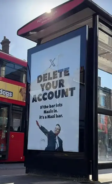 A billboard on the side of a bus shelter in London, UK with a red double decker bus in the background.

The billboard shows an image of Elon Musk giving a Nazi salute during the post-inauguration event for Donald Trump.

The billboard says "X DELETE YOUR ACCOUNT"

Subtitle: "If the bar lets Nazis in, it's a Nazi bar."