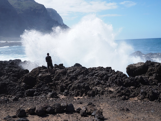 manstanding infront of a big wave