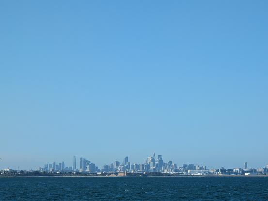 Sydney's metropolitan skyline seen across the bay area with Center Point Tower to the east on a very sunny warm blue sky afternoon