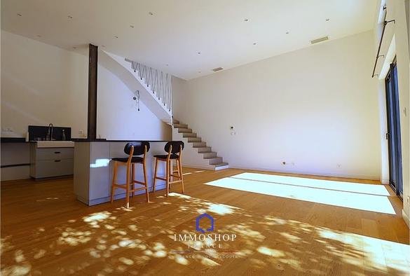Photo d'une grande pièce à vivre, parquet au sol, très lumineux, belle hauteur sous plafond