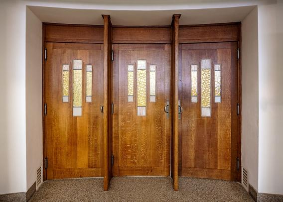 Triple doors in mahogany wood and rectangular stained glass windows at art deco style Bozar entertainment complex in Brussels by architect Victor Horta. These doors lead to the magnificent Henry Leboeuf performance hall.