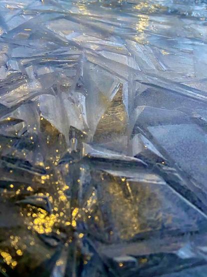 An even closer view of some thick cracked ice, with lots of yellow reflections from streetlights