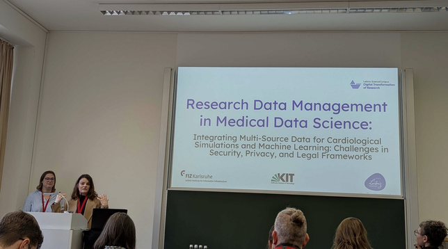 SIlvia Becker and Lea Sophie Singson presenting in front of the audience at EScienceTage 2025 in Heidelberg.