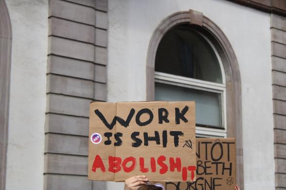 Pancarte "Work is shit abolish it" (Le  travail c'est de la merde, abolissez-le)