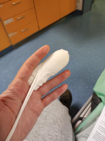 Fingerkuppenverband an einem Mittelfinger.