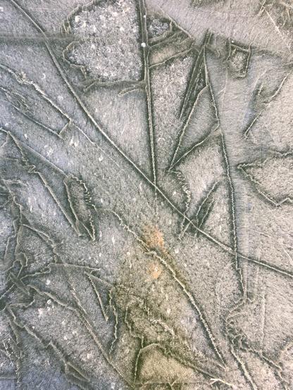 Cadre serré sur le lac des Brenets gelé. Des traits sont visibles sur la glace, rendant le tout assez abstrait.